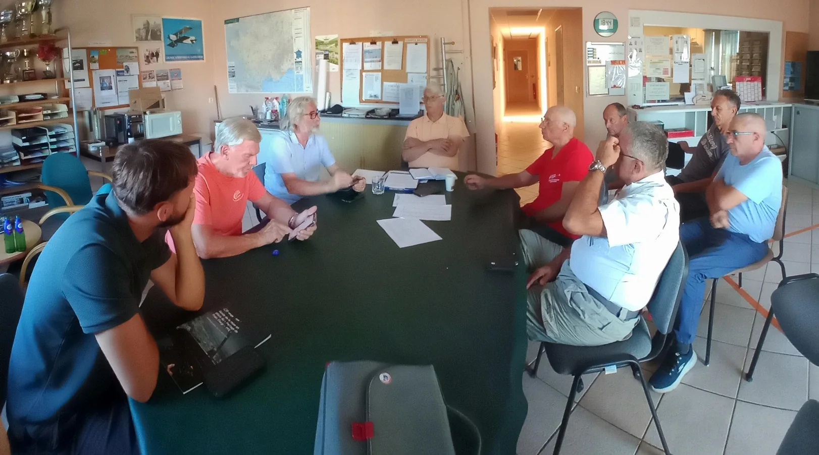 Membres du club réunis autour d’une table dans les locaux de l’aéro-club pour l’assemblée générale extraordinaire